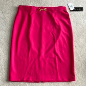Bright pink skirt with gold buckle detail.